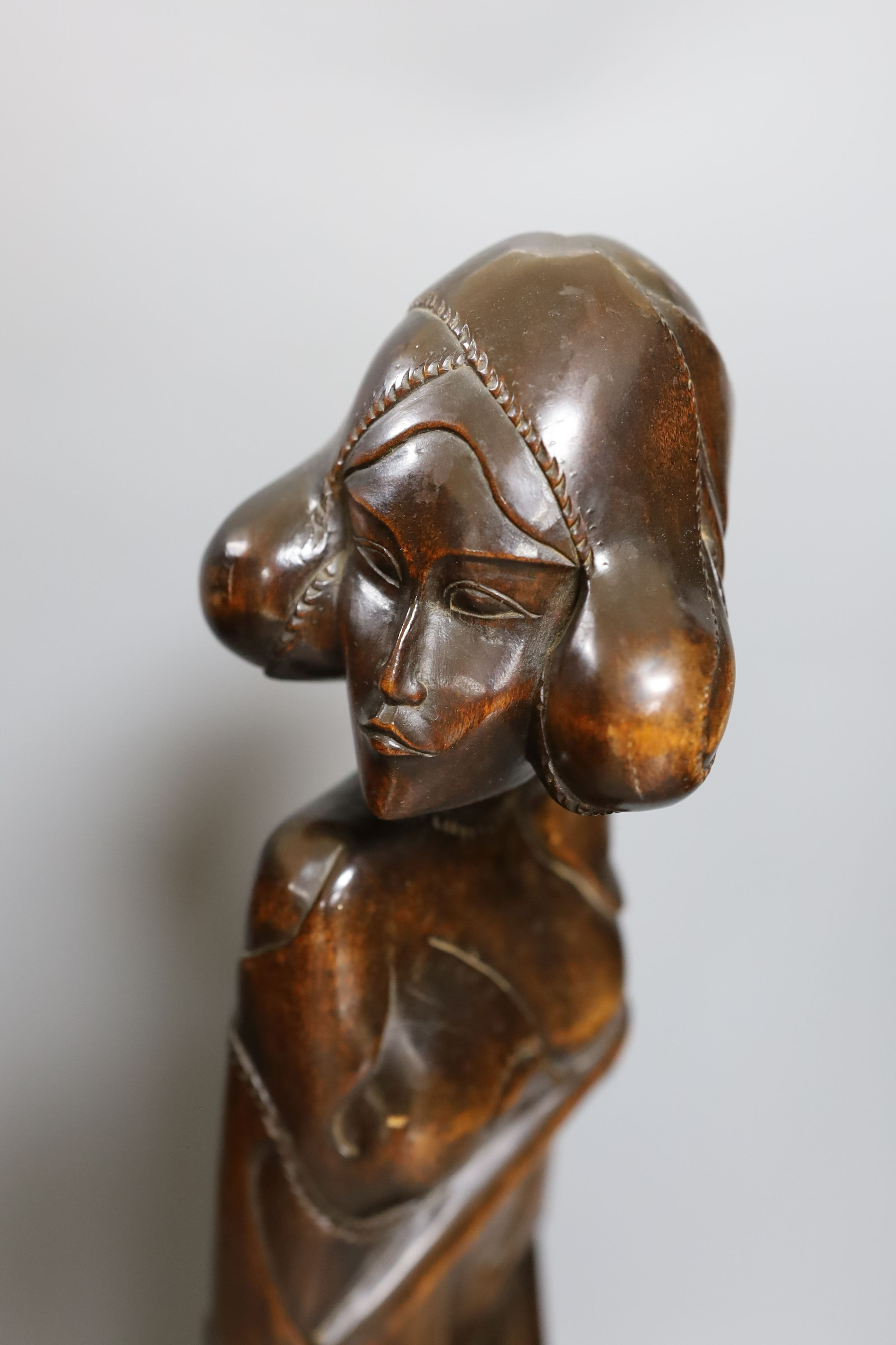 A Burmese carved hardwood figure, 51.5cm tall, and a Burmese horn and animal-bladder fan